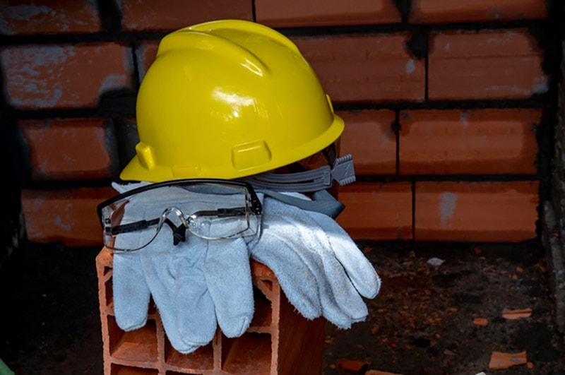 gloves, helmet and goggles on pile of bricks