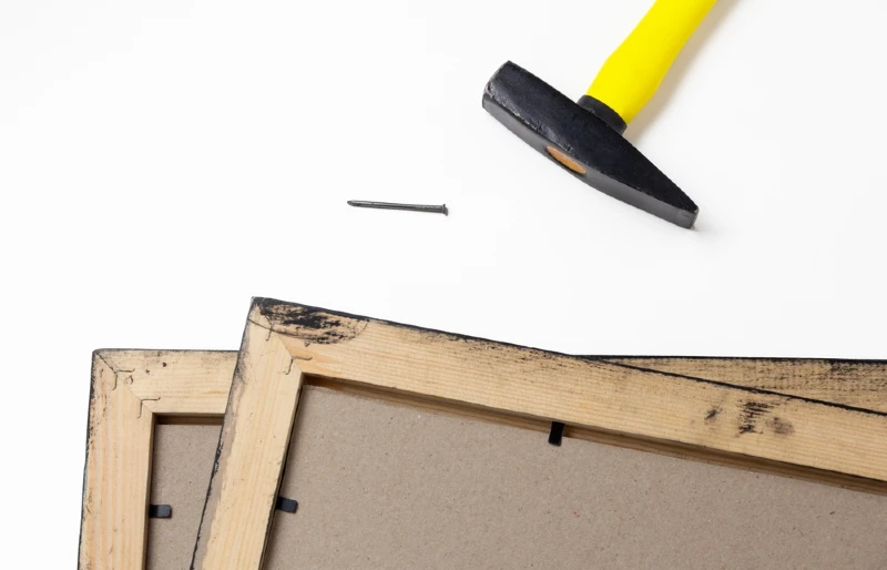 hammer and nail next to wooden frames