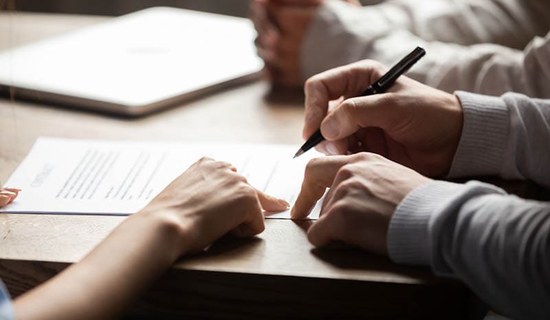 insurance contract showing male client where to write signature
