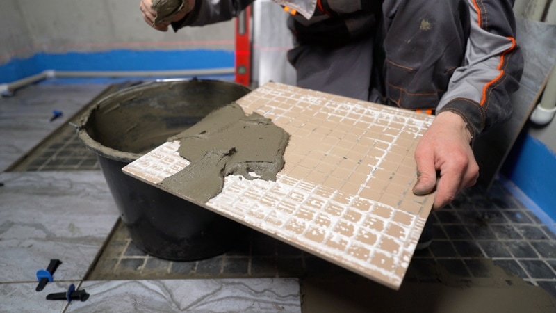man appling thinset mortar
