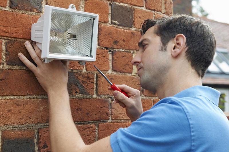 man fitting a floodlight