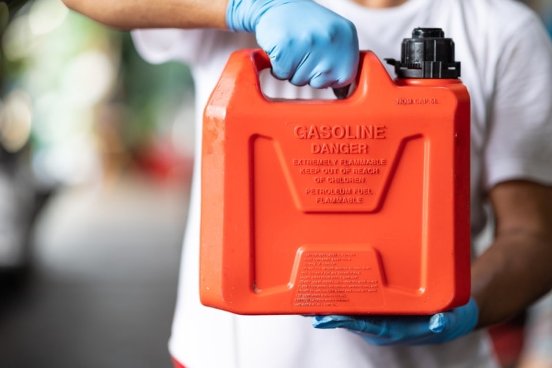 man holding gasoline container