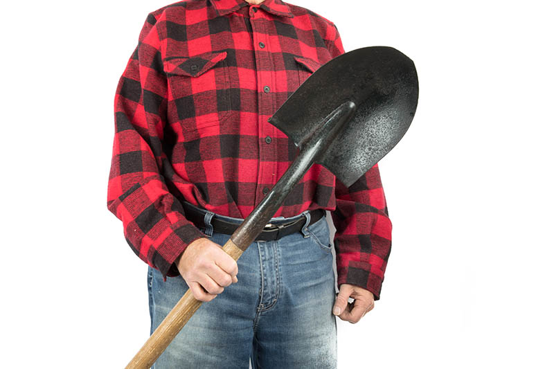 man holds a round nose shovel
