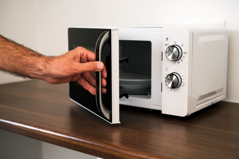 man opens microwave door