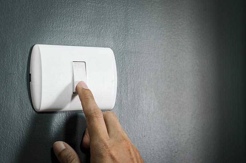 man turning on lighting switch
