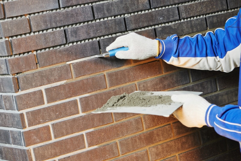man using brick jointer trowel