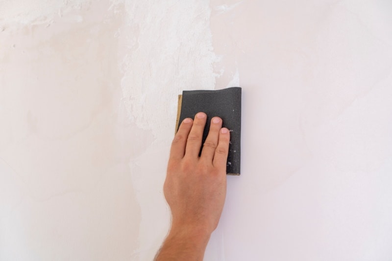 man using sand paper