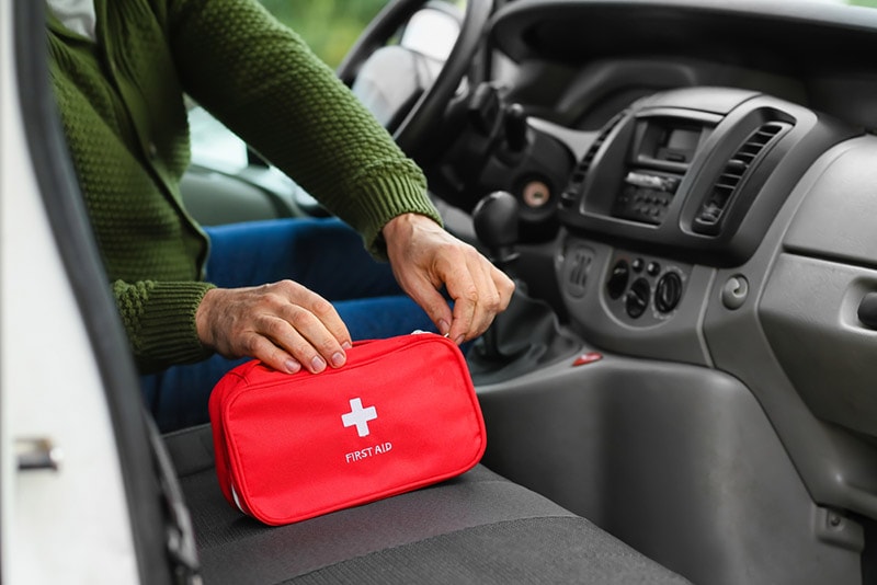 man with first aid kit in car