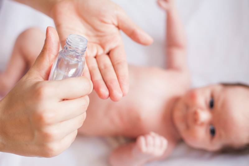 mother applying baby oil to her child