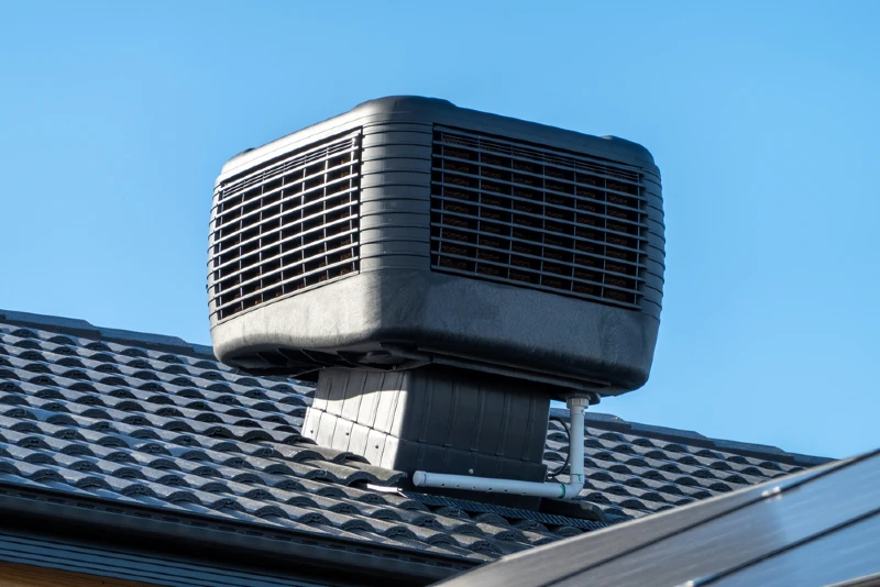 older style evaporative cooler or swamp cooler installed on the roof