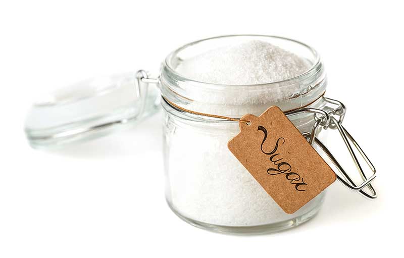 opened glass jar of sugar with label