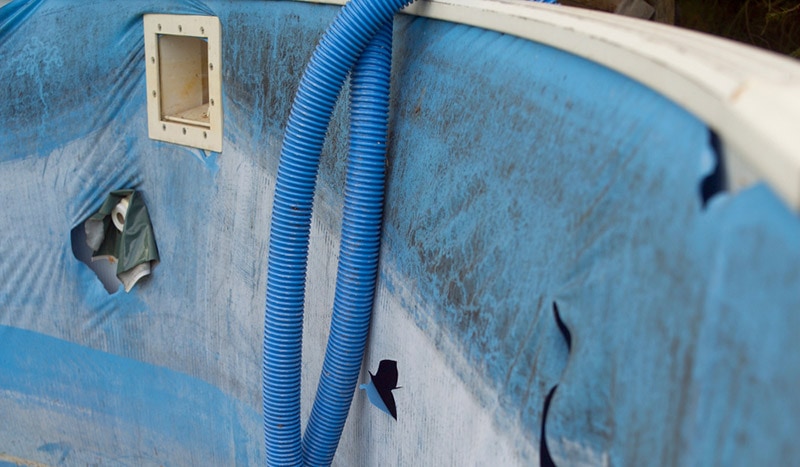 outdoor swimming pool with completely damaged liner