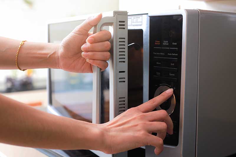 pressing buttons of a microwave