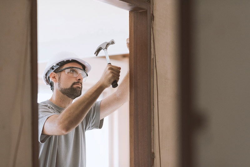professional carpenter installing a door jamb