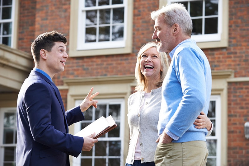 realtor showing couple around the house for sale