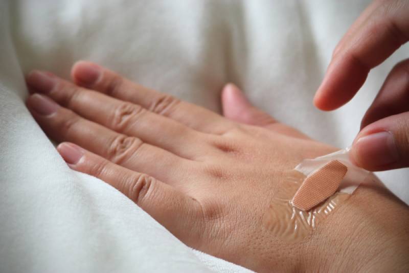 removing adhesive band aid from skin