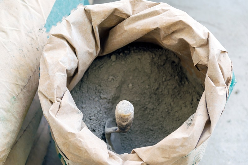 trowel and cement powder in paper bag