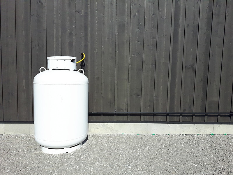 white propane gas tank outside the house