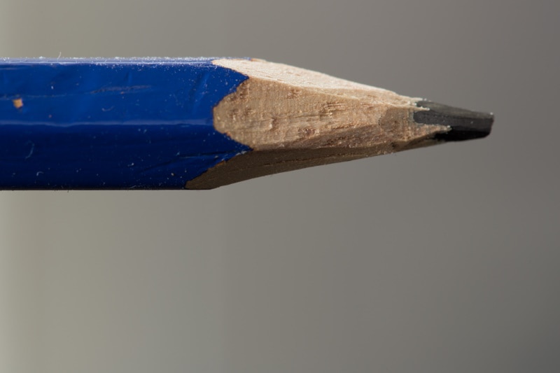 Blue pencil held up by hand