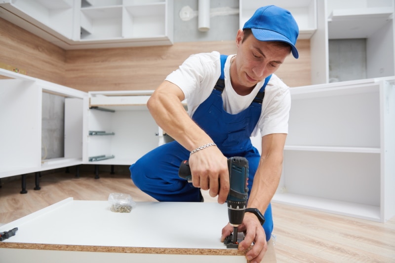 man assembling kitchen cabinet