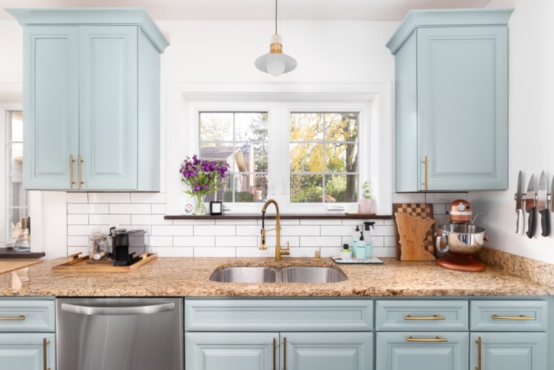 A light blue kitchen detail with a granite countertop