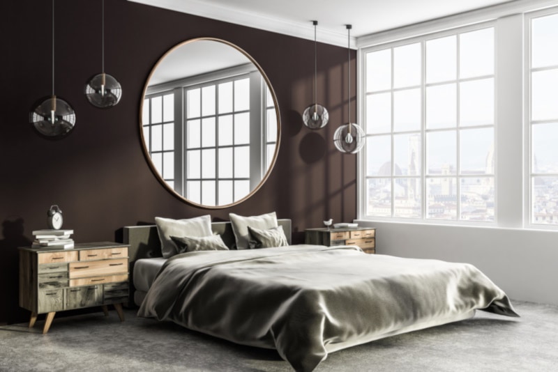 Corner of stylish bedroom with brown and white walls