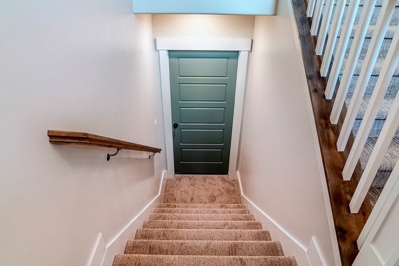 Interior U shaped staircase with wall mounted handrail and leads to the basement