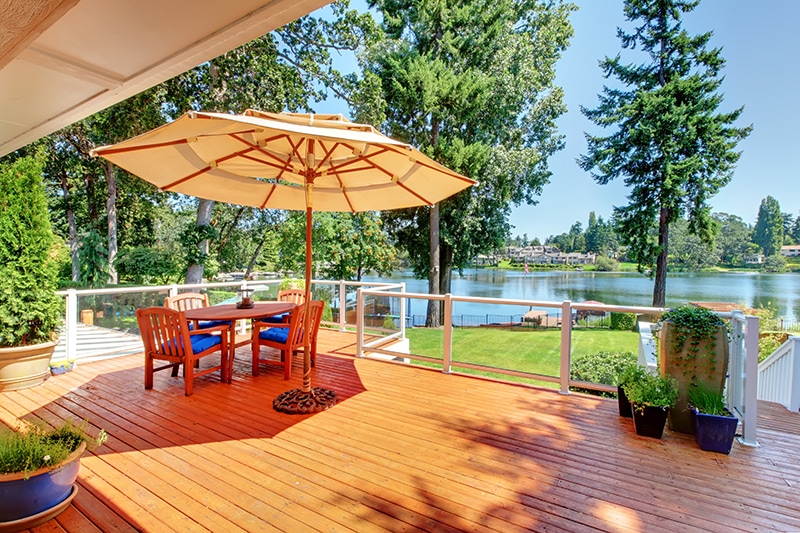 Large orange deck with umbrella and view of the lake