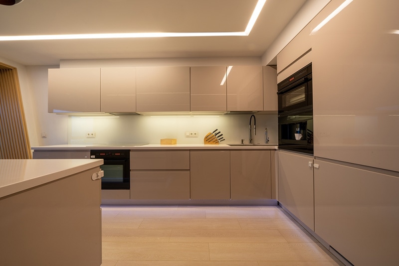 Light home interior in beige colors with open kitchen and dining area with bar counter