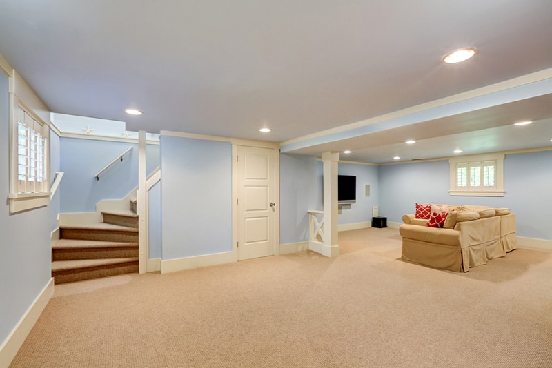 Spacious basement room interior in pastel blue tones