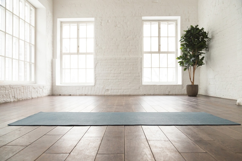 Unrolled yoga mat on wooden floor