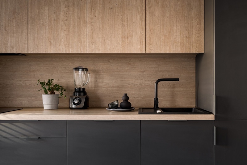 Wooden kitchen countertop with black sink and tap and decoration