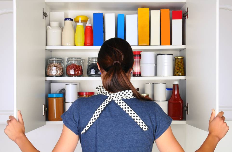 behind opening the doors to a fully stocked pantry