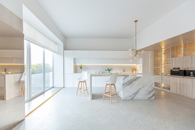 luxury interior design of modern trendy snow white kitchen in minimalistic style with island