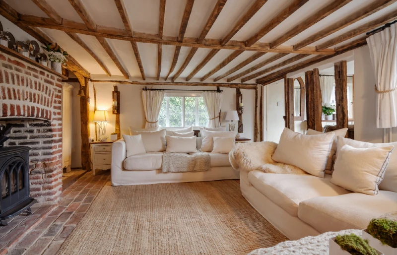 16th century english cottage living room with exposed beams and fireplace