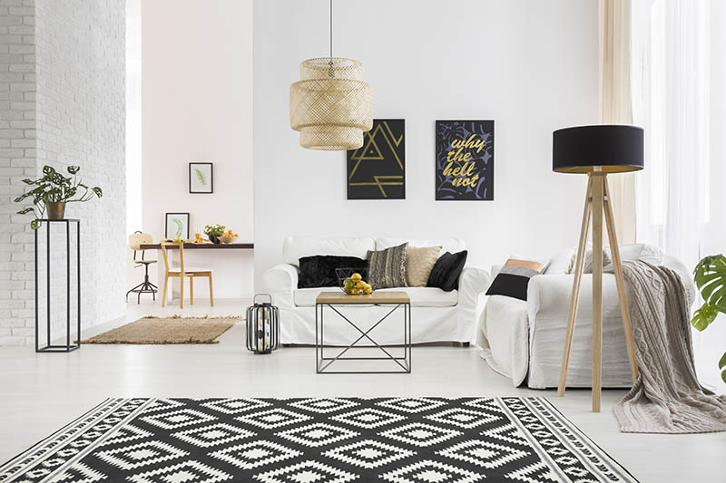 Apartment with white brick wall, sofa, table and pattern rug