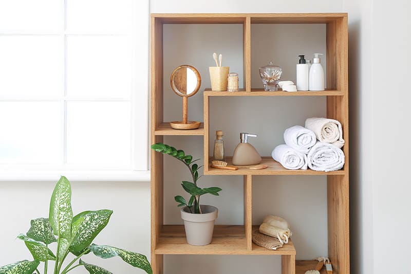 Body care cosmetics with accessories on shelves in bathroom