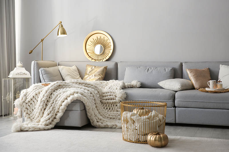Cozy living room interior with knitted blanket on comfortable sofa