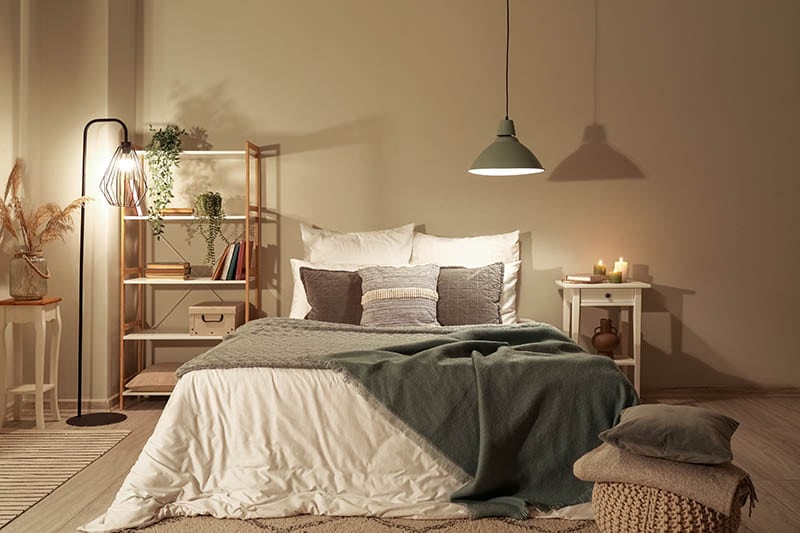 Interior of bedroom with green blankets on bed