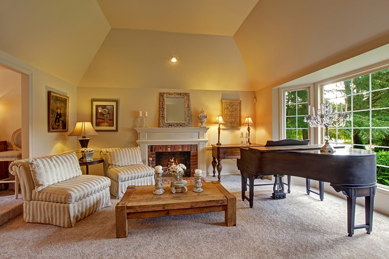 Luxury family room with high vaulted ceiling and large french window. Room has grand piano