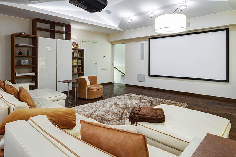 Theater room in luxury home with white big leather sofa and chairs