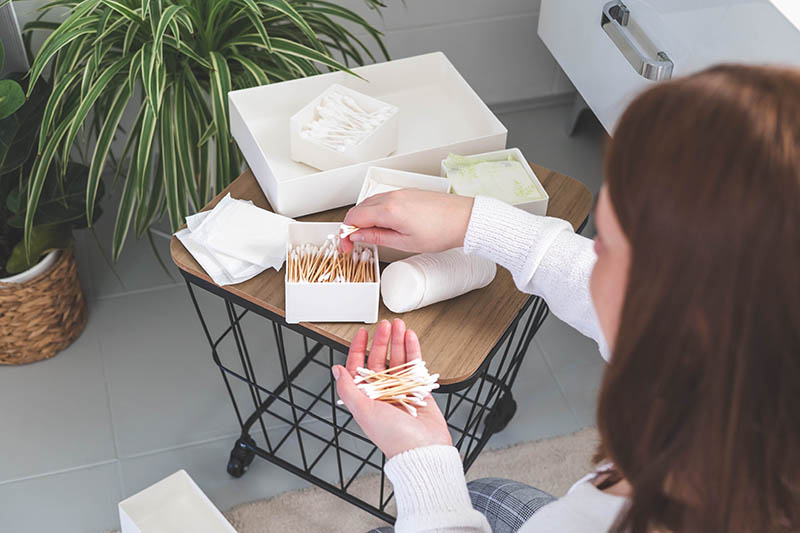 Top view of woman hands neatly organizing bathroom amenities and toiletries