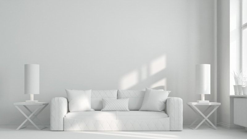 White sofa in white living room with empty wall