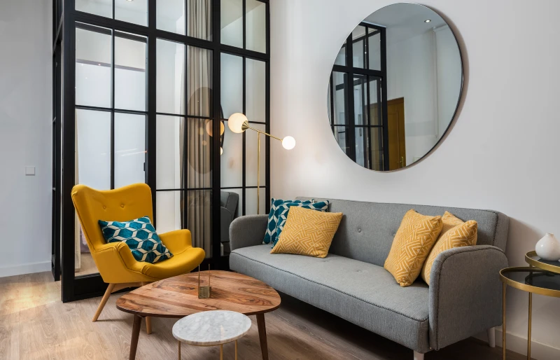modern cozy living room interior with designer armchair and sofa and round mirror