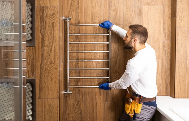 worker hanging towel rail in bathroom