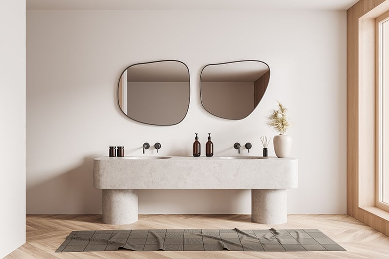 Beige bathroom interior with double sink and mirror, carpet on hardwood floor