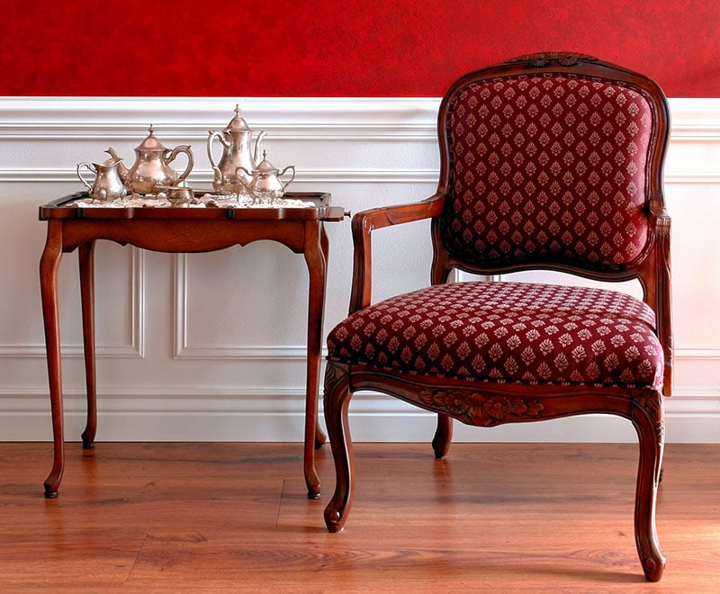 Colonial American style historic house interior with old tea tray table and antique chair