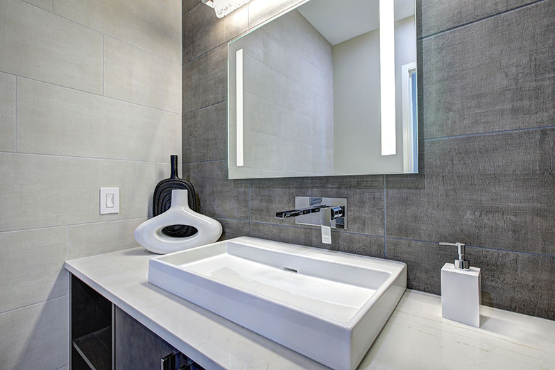 Contemporary bathroom interior with tile wall surround in grey tones