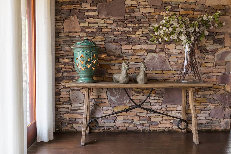Living room with decorative table, stone wall behind