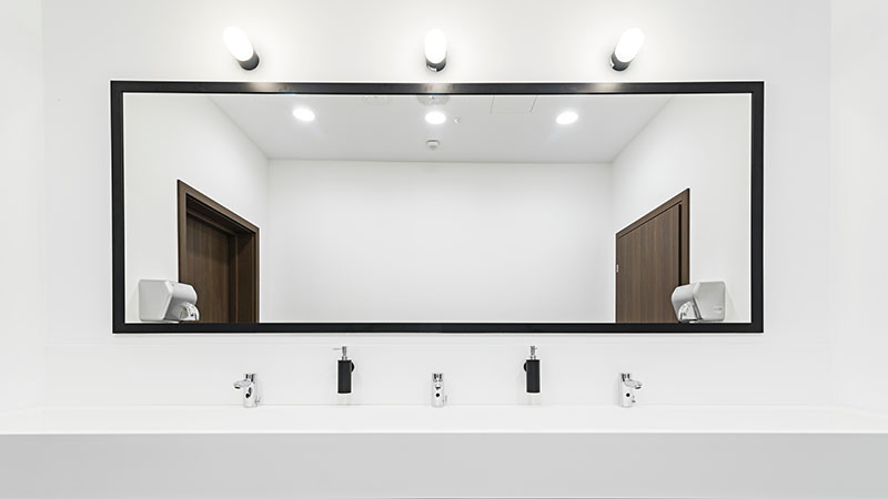 Modern toilet with a large illuminated mirror